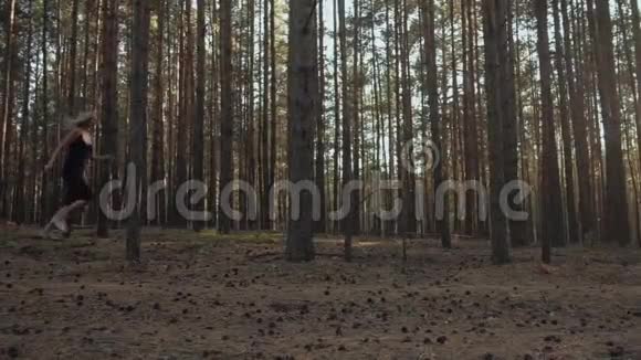 一个女孩在森林里用大松树奔跑视频的预览图