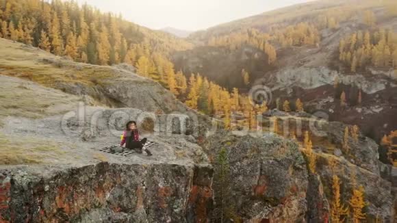 女人坐在高山上欣赏日落视频的预览图