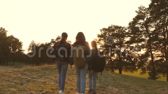 远足女孩三个女孩旅行穿过树林去爬山高兴地举起手来女孩旅行视频的预览图