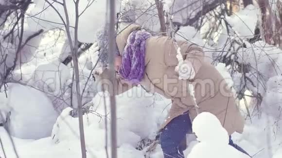 一场大雪中快乐的美女正在冬天的森林里散步视频的预览图