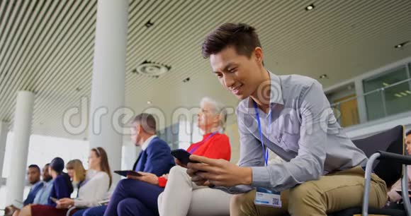 亚洲商人在商务研讨会上使用手机4k视频的预览图