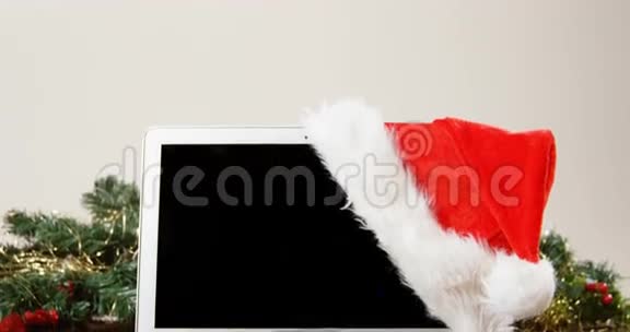 木板上有圣诞老人帽子的笔记本电脑视频的预览图