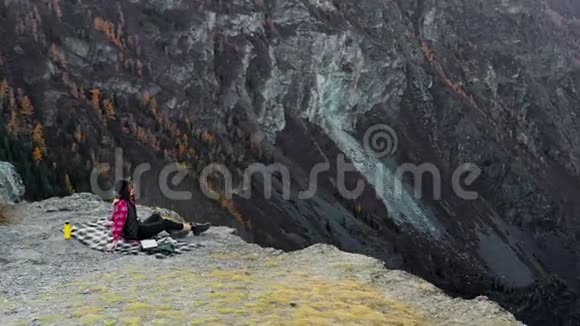 女人坐在高山上欣赏日落视频的预览图