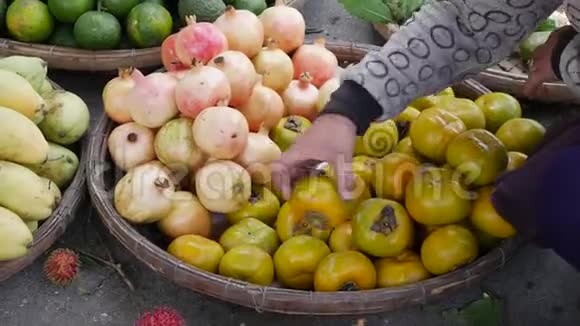 在当地的市场上女用手把篮子里的水果分类视频的预览图