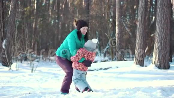 妈妈和小女儿在冬天的户外雪地里玩耍和欢笑视频的预览图