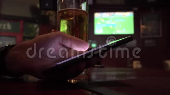 在酒吧喝啤酒时使用手机拉近人的视野视频的预览图
