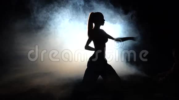 女运动员展示力量动作黑色的剪影背光灯视频的预览图