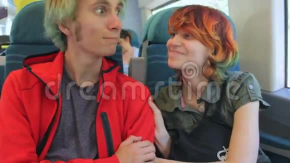 年轻漂亮快乐的时髦夫妇坐在火车旁谈笑风生暑假视频的预览图
