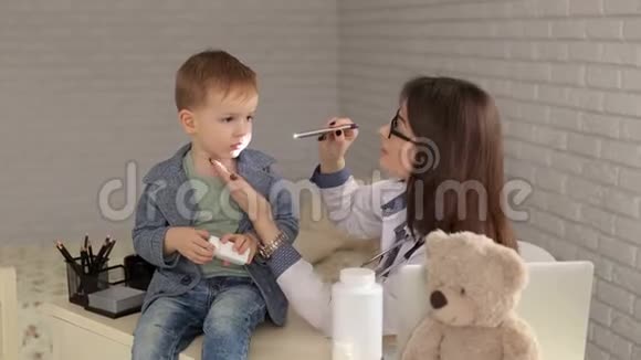 医生用手电筒检查男孩的喉咙视频的预览图