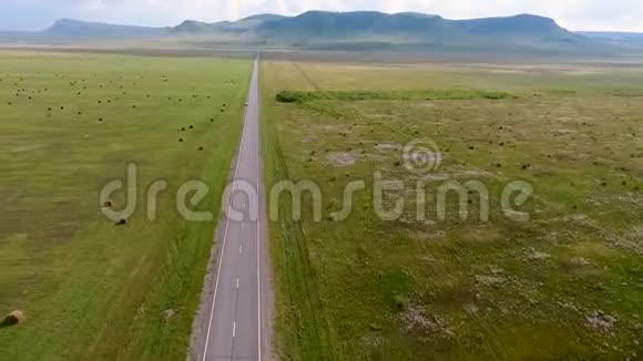 从空中看到哈卡西亚共和国无尽的田野山丘干草堆道路和汽车俄罗斯视频的预览图