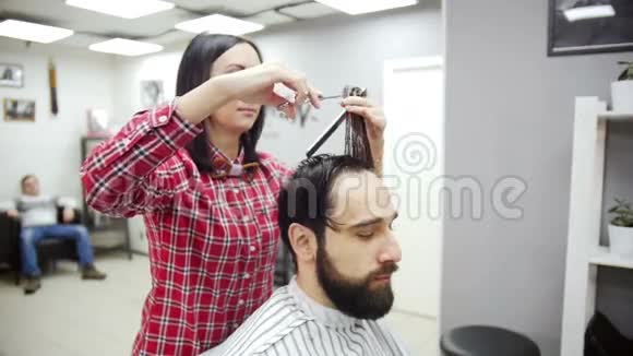 理发师用剪刀剪客户的头发慢动作视频的预览图