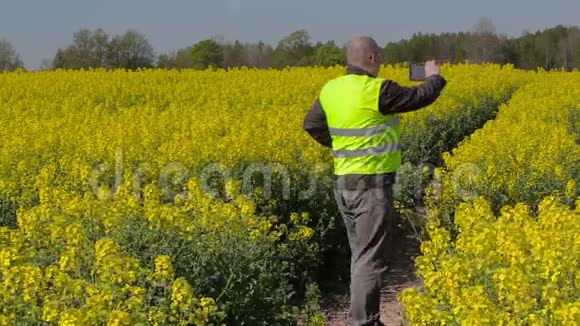 农民用智能手机拍照在田里散步视频的预览图