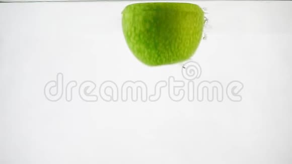 绿苹果掉进水里在白色背景下缓慢移动的孤立苹果视频的预览图