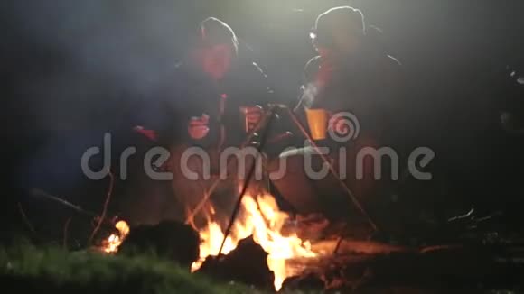 两个朋友晚上坐在柴火旁边聊天喝茶视频的预览图