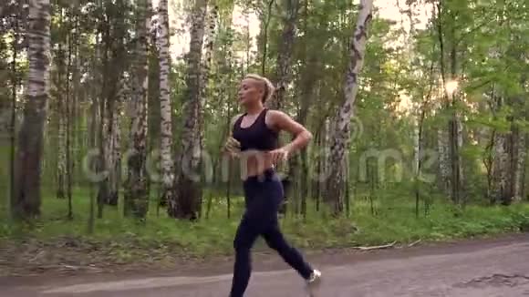 强壮的女孩在夏天的森林里慢跑肌肉运动员在大自然中奔跑慢动作视频的预览图