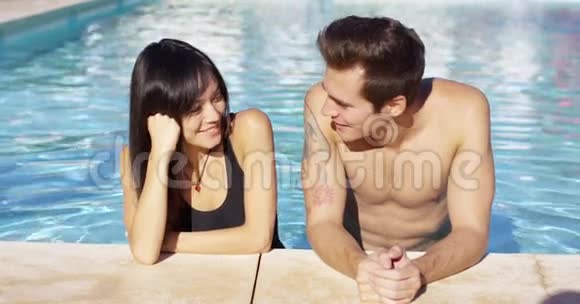 一对漂亮的棕色头发的蓝泳池夫妇视频的预览图