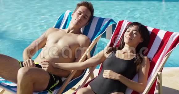 爱年轻夫妇在甲板椅上晒日光浴视频的预览图