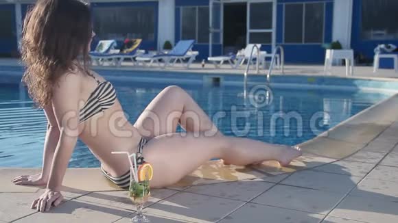 迷人的女人放松快乐的女人在游泳池里享受日落视频的预览图
