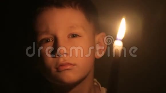 一个孩子手里拿着燃烧的蜡烛视频的预览图