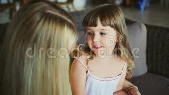 年轻的母亲和她的小女儿在沙发上接吻视频的预览图