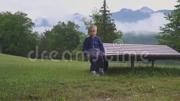 小男孩走在山湖附近在大自然中奔跑嬉戏视频的预览图