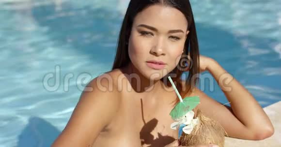 带着诱惑的年轻女人喝椰子鸡尾酒视频的预览图