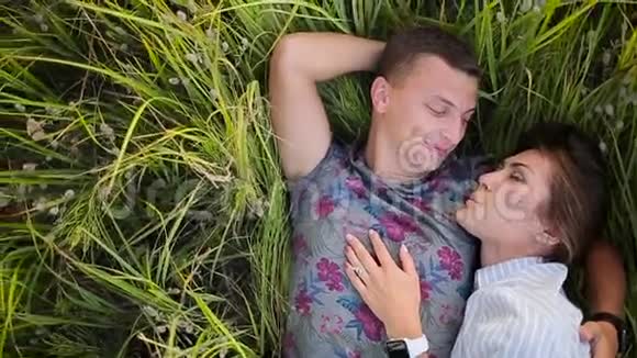 一对躺在草地上微笑的夫妇视频的预览图