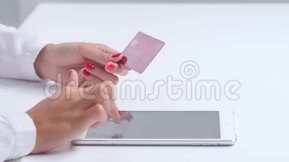 女孩使用平板电脑和信用卡进行网上购物关门视频的预览图