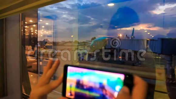 机场暗窗中女孩的手机屏幕反射视频的预览图