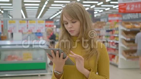 商店里的年轻女性在触摸板上检查产品清单视频的预览图