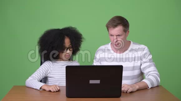 年轻的非洲女孩和年轻的斯堪的纳维亚人一起使用笔记本电脑视频的预览图