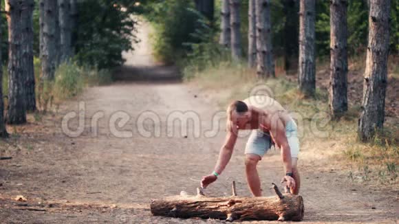 强壮强壮的男人在森林道路上举起一根木头视频的预览图