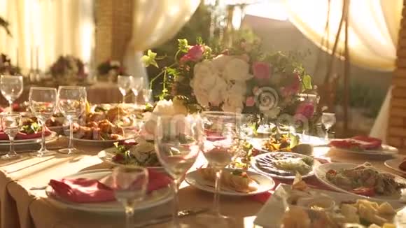 婚礼桌乡村风格的装饰与菜肴饮料和花的粉红色和米色各种植物组成视频的预览图