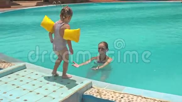 在酒店的游泳池里小女孩跳进母亲的怀抱视频的预览图