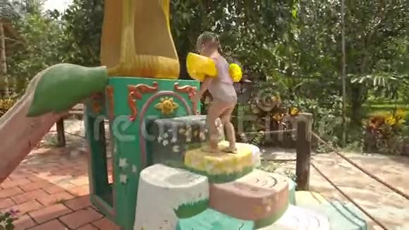 小女孩爬上水坡的台阶在水池边视频的预览图