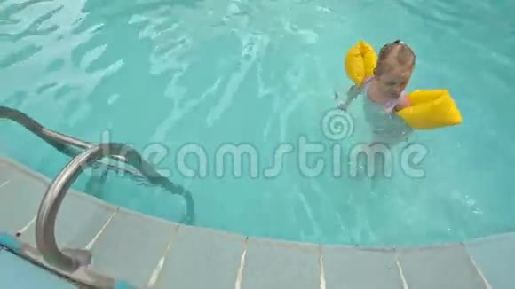 小女孩和梯子一起从游泳池出来防止滑水视频的预览图