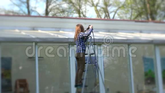 女性用高压工具清洁玻璃屋盖视频的预览图