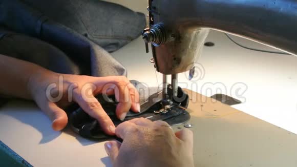 家里的女裁缝女性手缝牛仔裤一台缝纫机在工作视频的预览图