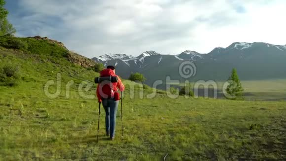 那个背着红色背包的女人悲伤地走上前去雪山景色早晨的太阳手里拿着棍子的女人视频的预览图