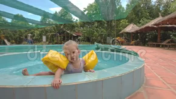 小女孩在酒店用雨伞爬出游泳池视频的预览图
