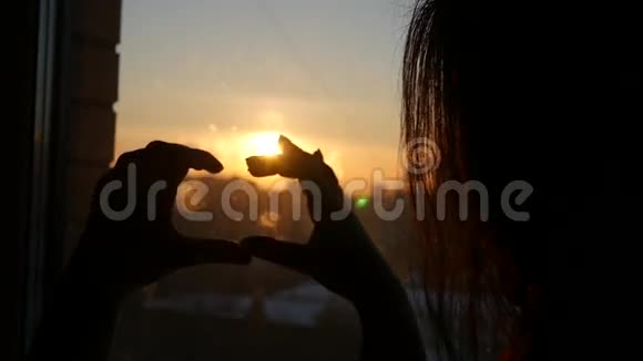 年轻的女孩承认他的爱并使浪漫的心在美丽的日落背景下慢慢地视频的预览图