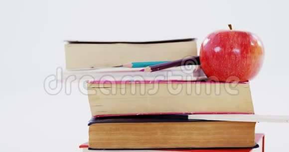 书籍彩色铅笔和苹果白色背景视频的预览图