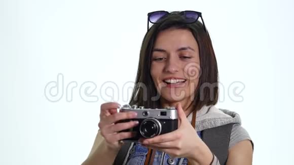 年轻漂亮的女摄影师带着老式相机拍照工作室在白色背景上拍摄美丽美丽视频的预览图