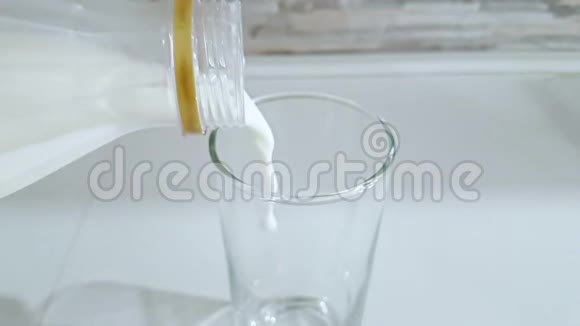 在厨房背景下新鲜的白牛奶倒入酒杯中拍摄时动作缓慢饮食健康营养健康视频的预览图