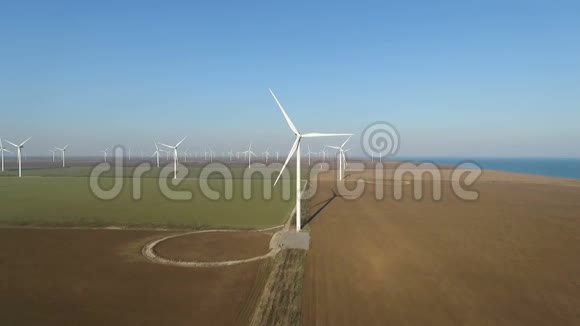 靠近大海的田野里的风力涡轮机视频的预览图