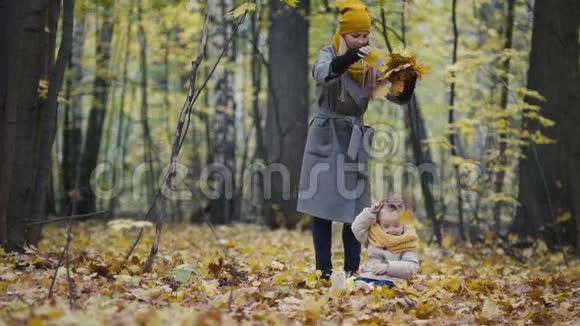 妈妈和她的女儿小女孩在秋天的公园里散步妈妈和孩子玩得很开心玩视频的预览图