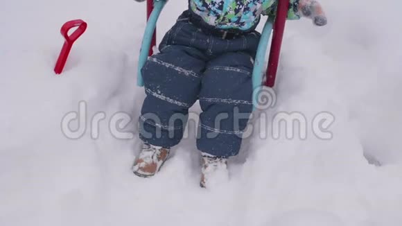 一个小孩子在冬天公园玩秋千上的一个孩子晴朗的冬日新鲜空气中的乐趣和游戏视频的预览图