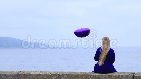 激动的年轻女子拿着紫色的心脏气球视频的预览图