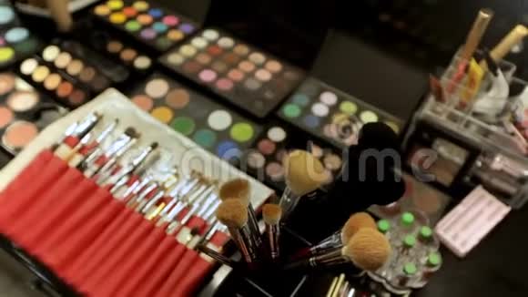 专业的化妆品化妆师在工作室的桌子上五颜六色的口红阴影和各种视频的预览图