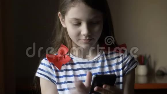 微笑的女孩在家里的智能手机上发短信视频的预览图